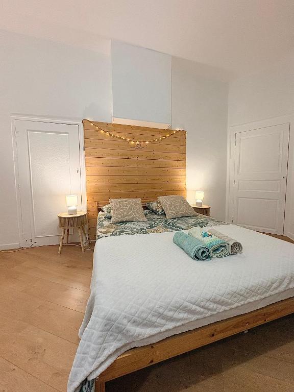 a bedroom with a large bed with a wooden headboard at Studio le «Victor Hugo» , hyper centre ville in Vienne