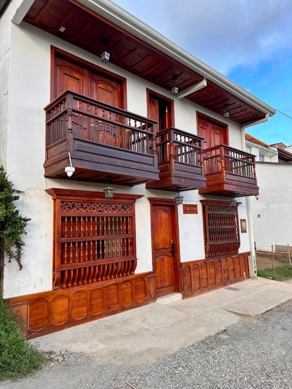 ein Haus mit Holztüren und einem Balkon in der Unterkunft Los Barranqueros Hotel in Salento