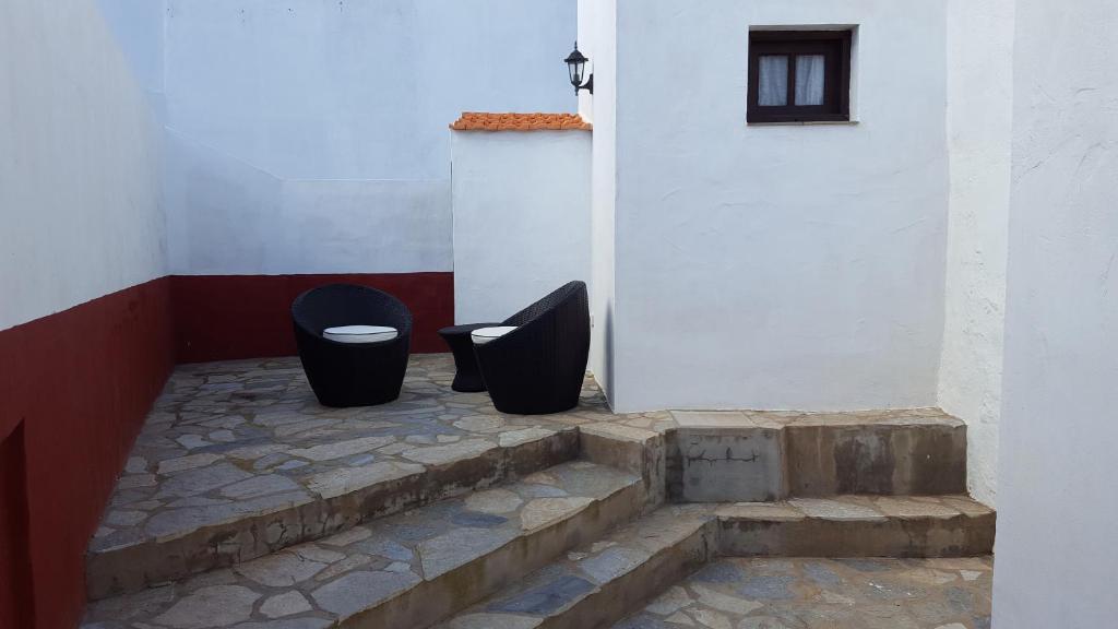 Due bidoni della spazzatura neri seduti accanto a un edificio. di Casa Rural Domingo Pio a Echedo