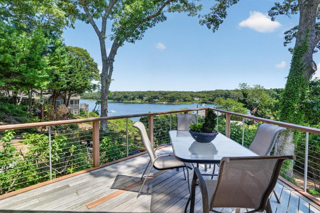 a deck with a table and chairs and a view of a river at Steps to Beach: Martha's Vineyard Private Retreat! in Vineyard Haven