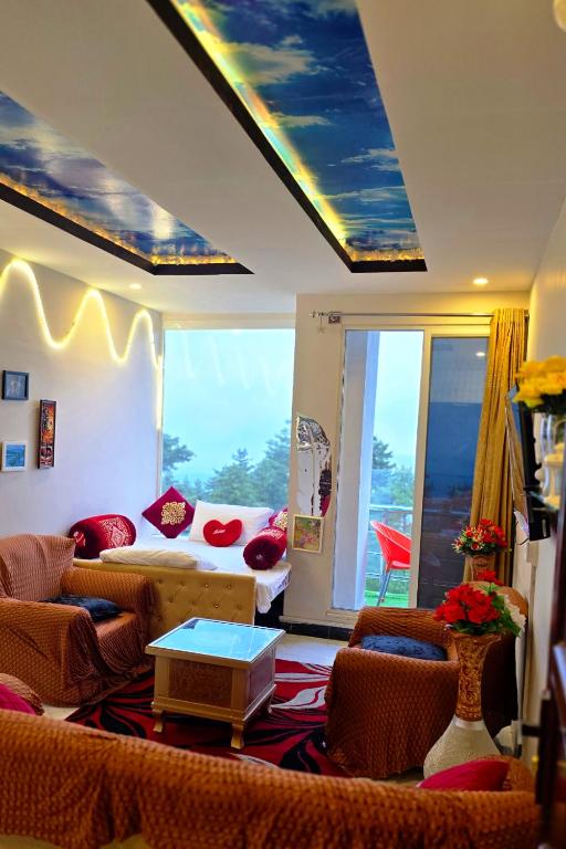 a living room with a bed and chairs and a window at Bhurban Nights - Glass Bed Murree Hills View - Lift - 15 Minutes from Murree & Mallroad in Murree