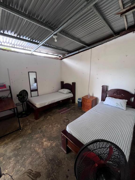 a room with two beds in a room with a bed istg at Hostal Sol Naciente in Rivas