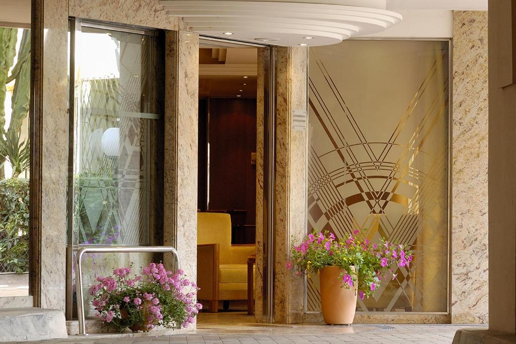 eine Lobby mit zwei Blumenvasen in einem Gebäude in der Unterkunft Residence Club Inn in Nizza