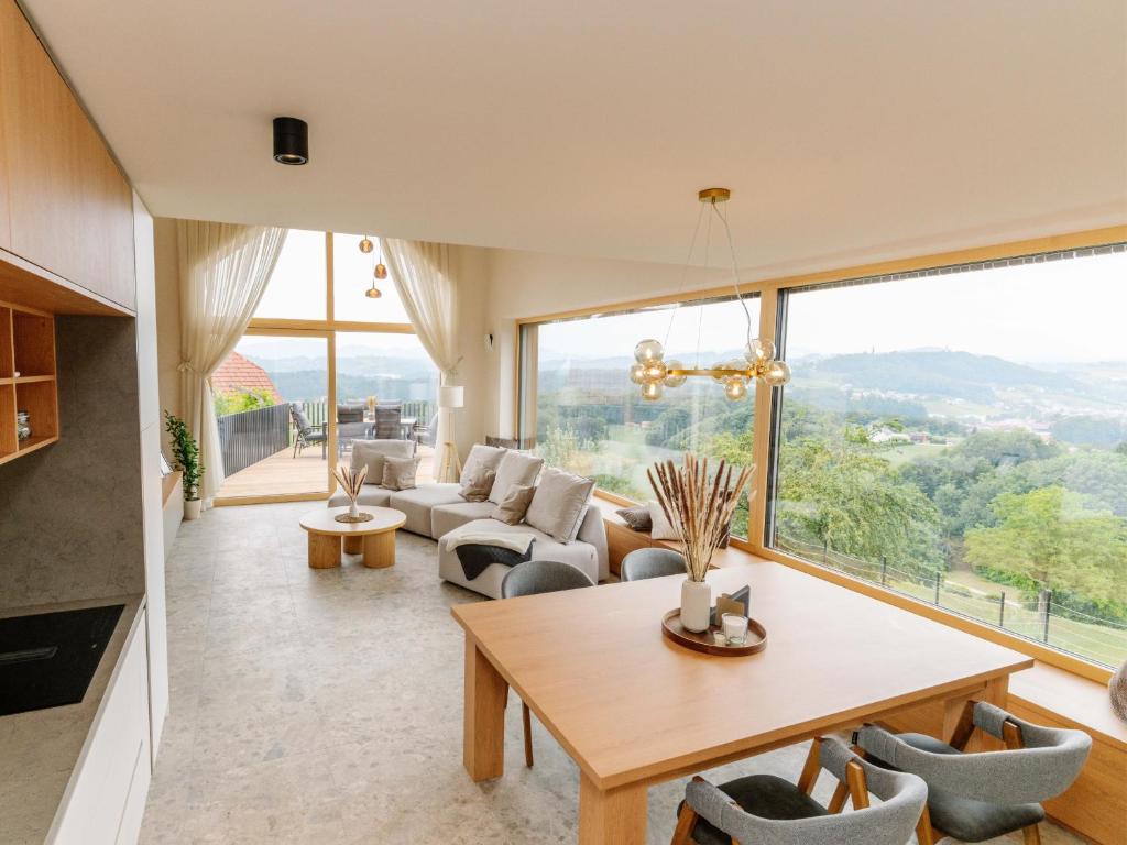 a living room with a table and chairs and a large window at Brioni Hills - Premium Escape in Šmarje pri Jelšah