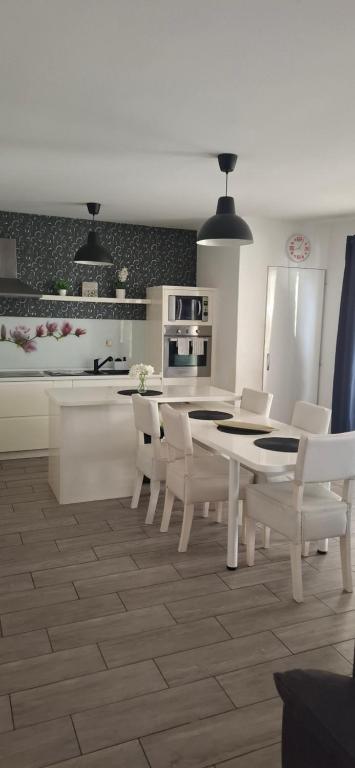 a kitchen with a white table and white chairs at LaLuna House in Cernik