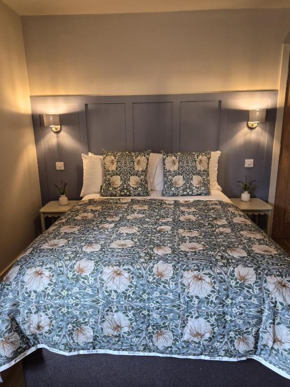 a bedroom with a large bed with a floral bedspread at Clarke Cottage Guest House in Dunfermline
