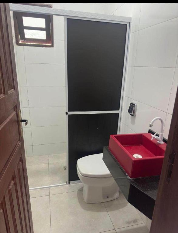 a bathroom with a red sink and a toilet at Florence Nightingale in Sorriso