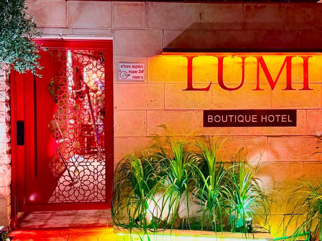 a building with a red door and a boutique hotel at Lumi Hotel Eilat - מלון בוטיק באילת in Eilat