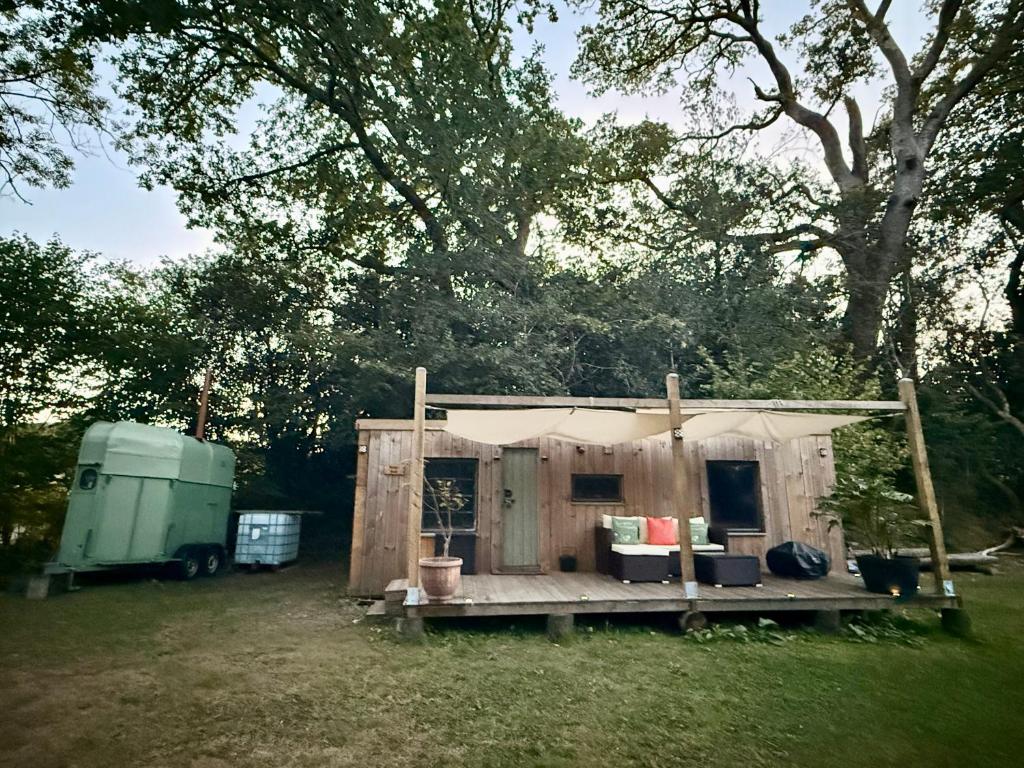 a tent with a table and a trailer in a field at Nesta's Nook in Llandovery