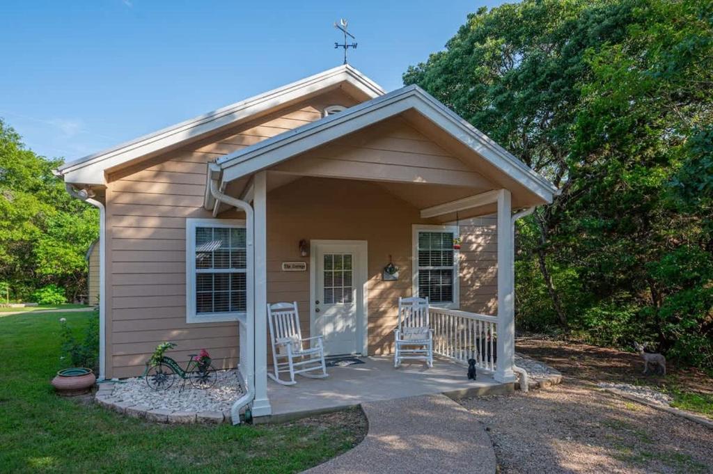 a small house with two chairs on a porch at Cozy Cottage in Waco