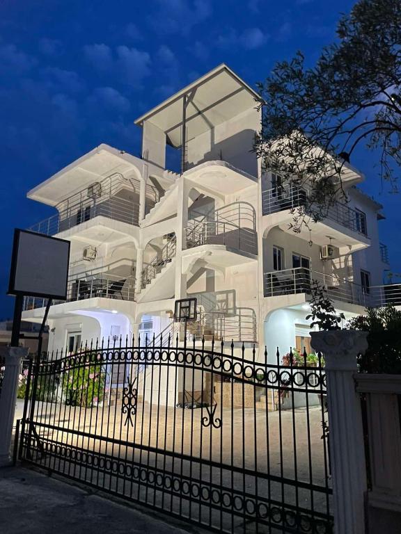 a white building with a fence in front of it at Apartments Armini in Ulcinj