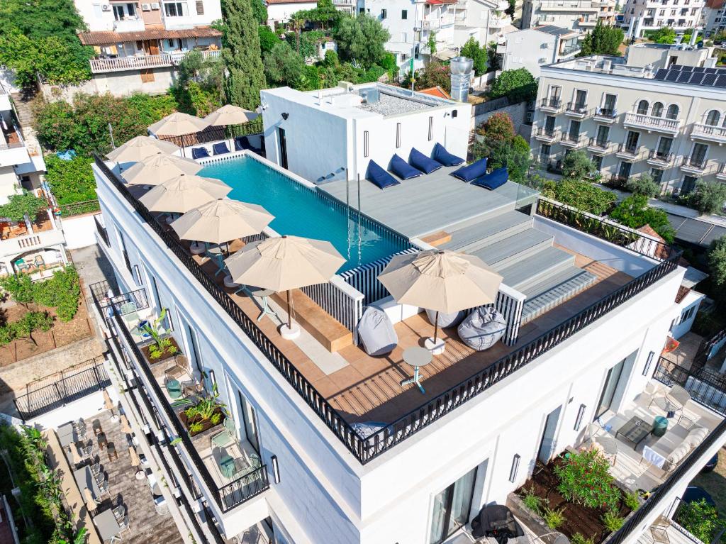 an aerial view of a building with a swimming pool and umbrellas at Hotel Madeira in Budva