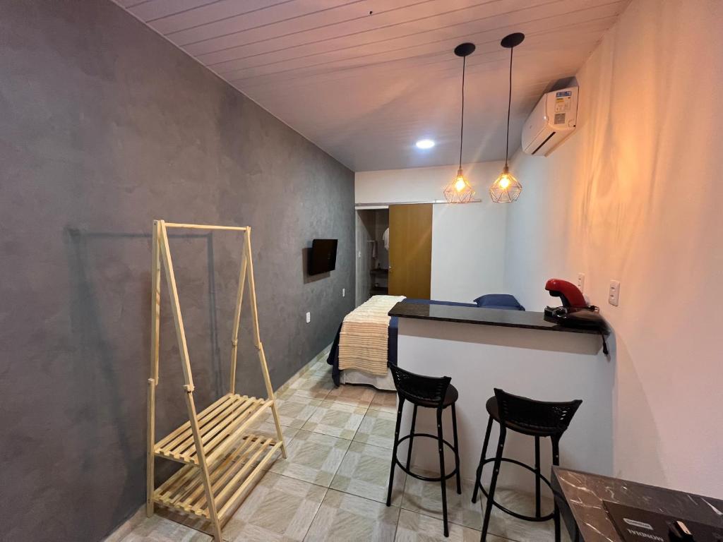 a room with a table and chairs and a bed at Aura Mar Flat in Baía Formosa