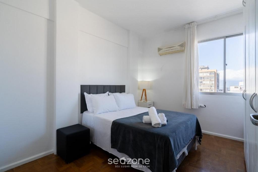 a white bedroom with a bed and a window at Apt in Downtown Floripa CAT0905 in Florianópolis
