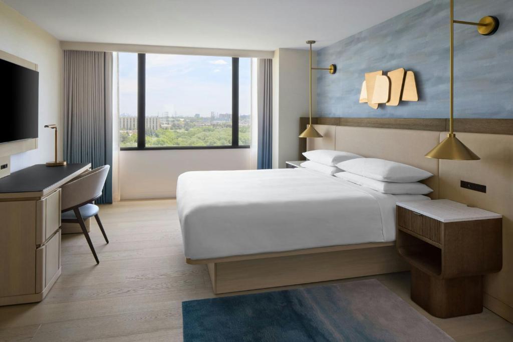 a bedroom with a bed and a desk and a television at Toronto Airport Marriott Hotel in Toronto