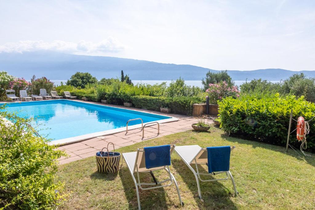 a yard with chairs and a swimming pool at Villa Francesca Toscolano in Toscolano Maderno