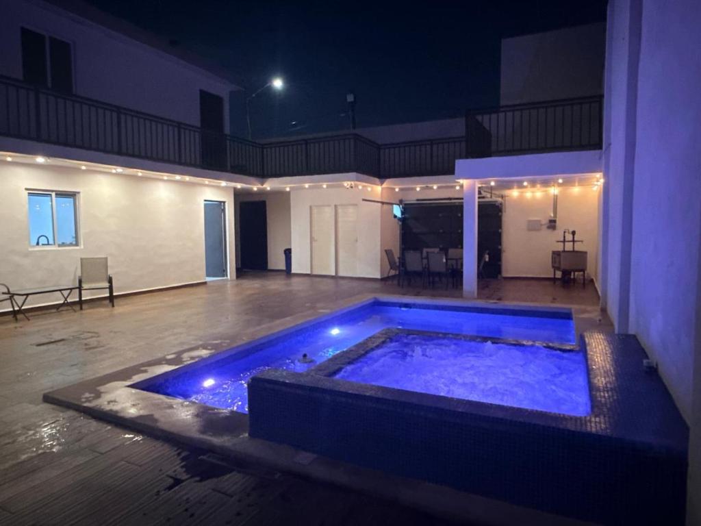 a large blue hot tub in a building at night at Lujoso departamento con alberca y jacuzzi in Monterrey