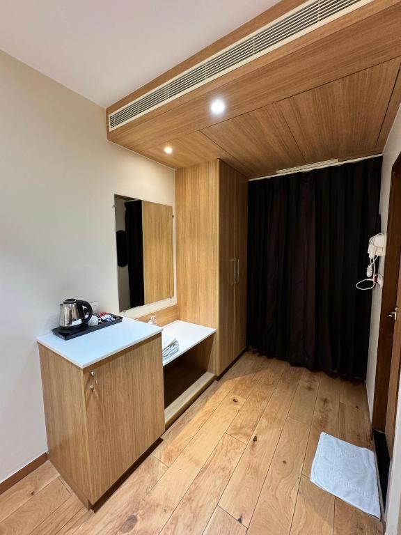 Ein Zimmer mit einer Küche mit Theke und Holzboden in der Unterkunft Hotel connectzone in Visakhapatnam