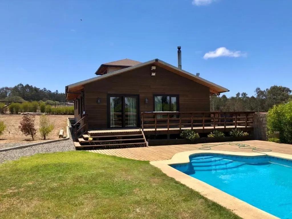 a house with a swimming pool in front of a house at Casa Monita in El Quisco
