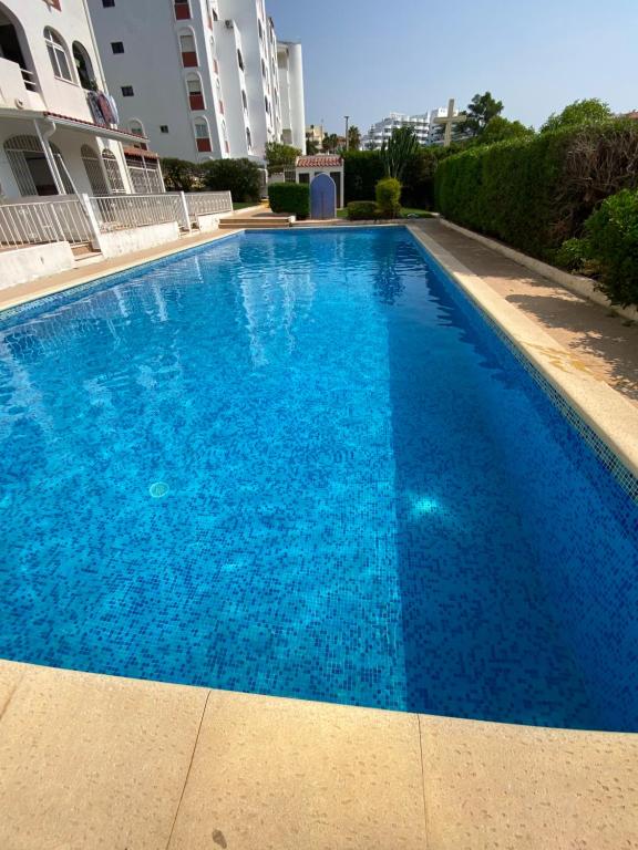 a large blue swimming pool in front of a building at Apartamento Oceano in Albufeira