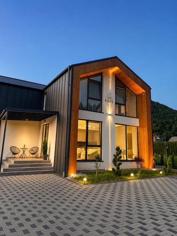 a modern house with a lit up facade at The NEST Villa in Borşa
