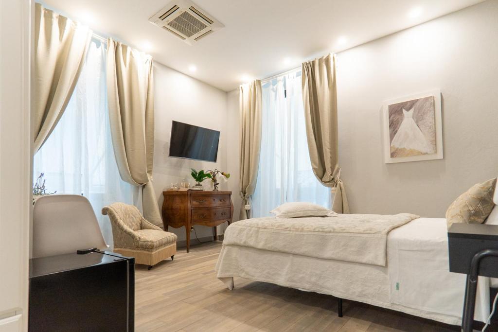 a bedroom with a bed and a chair and a television at Covo di Levante, in La Spezia