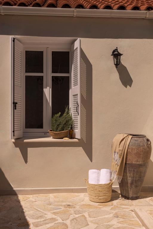 a window with two baskets of towels and a window with a window at Ithaca Garden Villa, Kioni in Kiónion