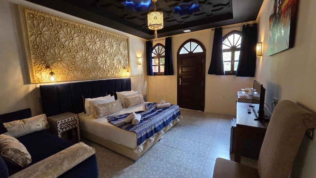 a bedroom with a bed and a couch at Palace Africa - Marrakech Palmeraie in Marrakesh
