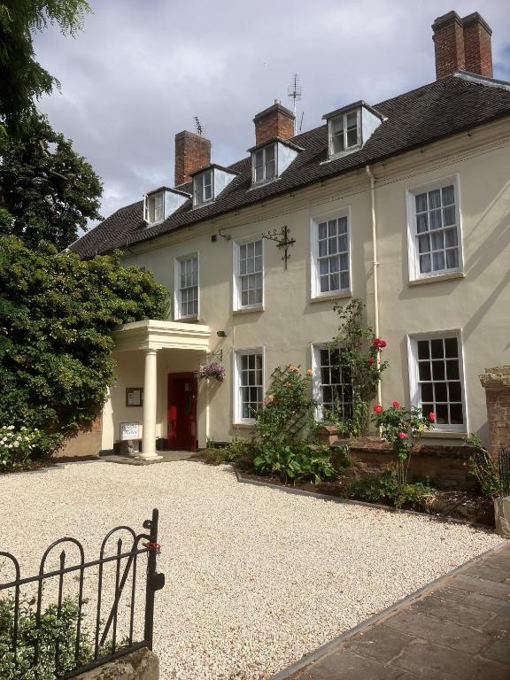 a white house with a bench in front of it at Chapel House in Atherstone