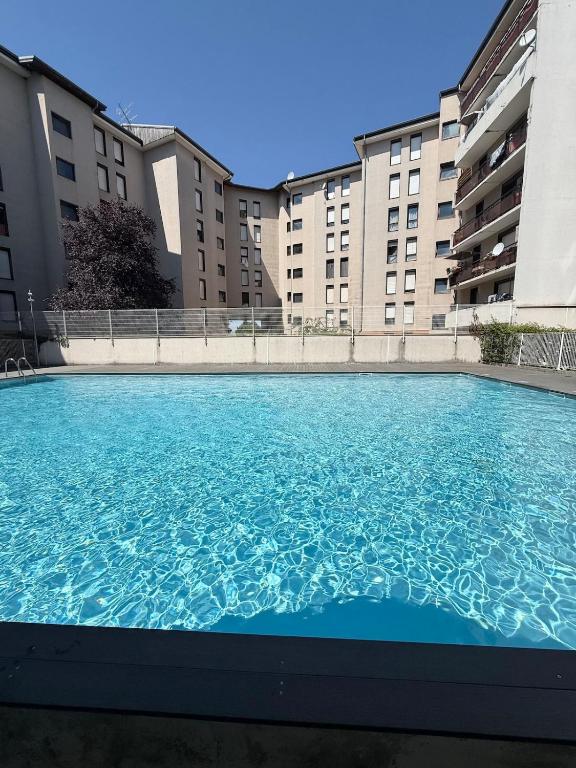 a large swimming pool in front of some buildings at Large studio Independent sleeping area Swimming pool in Annemasse