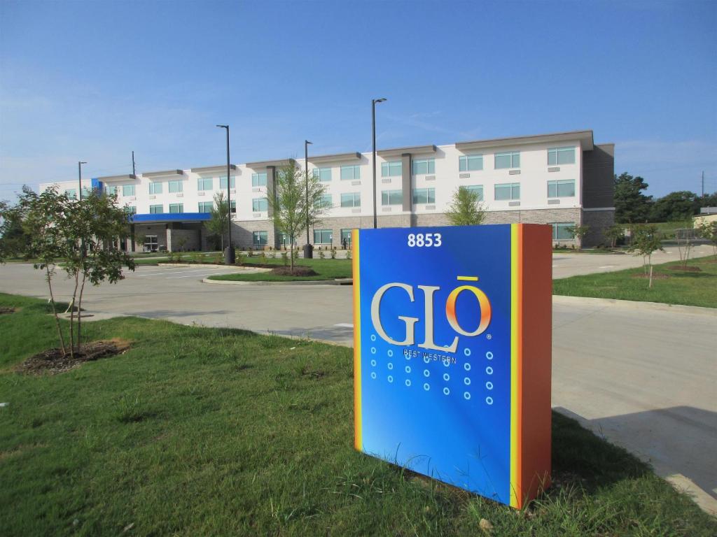 a gio sign in the grass in front of a building at Glo Best Western Olive Branch in Olive Branch