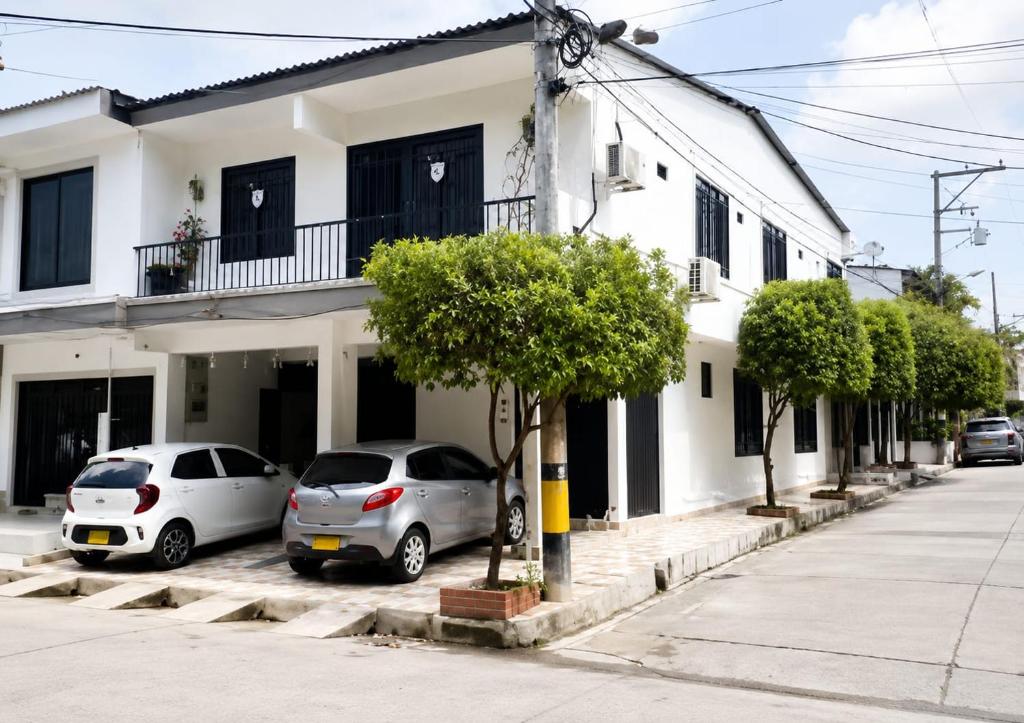two cars parked in a parking lot in front of a house at Hostal Mi Puerto in Puerto Triunfo
