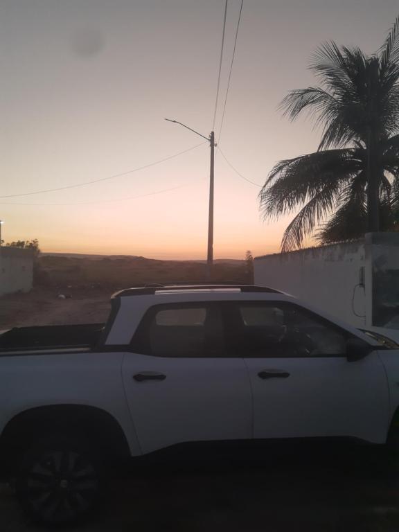 a white truck parked in front of a palm tree at Casa Marina Morro Branco in Beberibe
