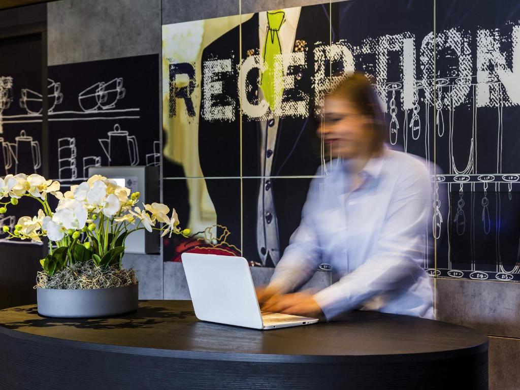 a man sitting at a table with a laptop at ibis budget Stein Maastricht in Stein