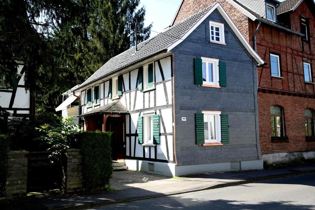 uma casa a preto e branco com persianas verdes em Ferienhaus "Einfach Schön" em Windeck