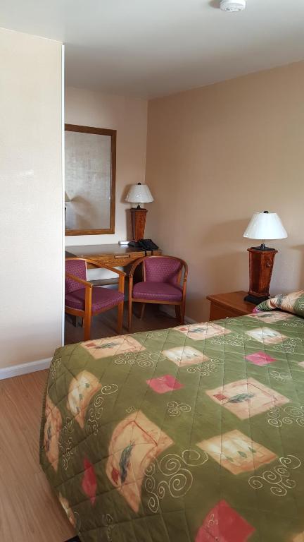 een hotelkamer met een bed en een tafel en stoelen bij Maples Motel in Orillia