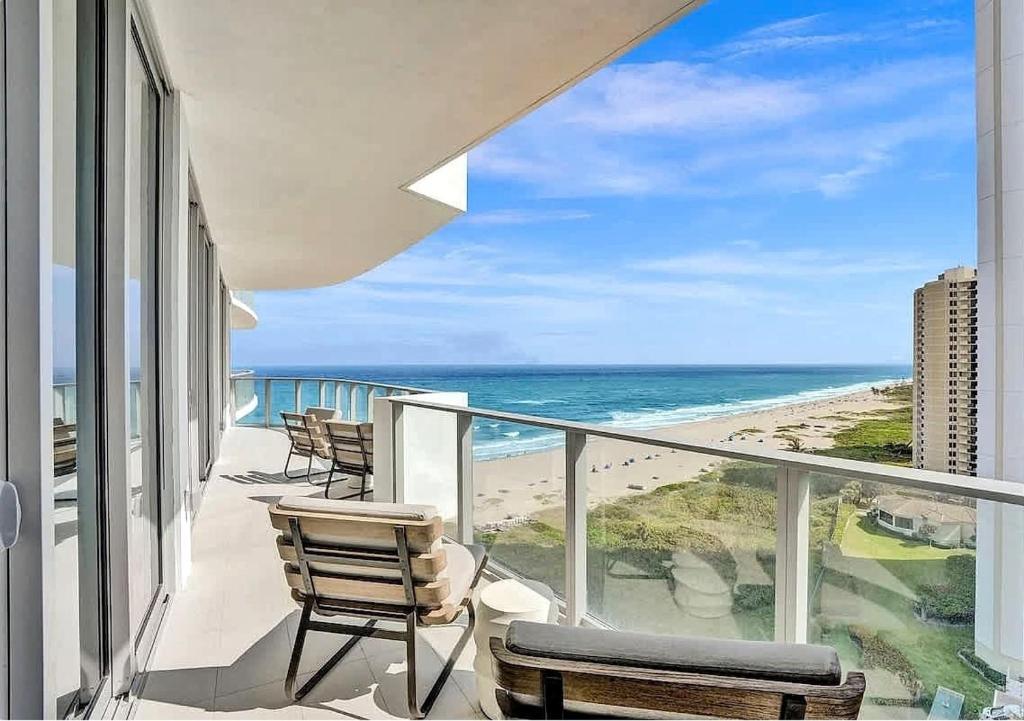 a balcony with chairs and a view of the ocean at Luxury Ocean View 2BR in Riviera Beach