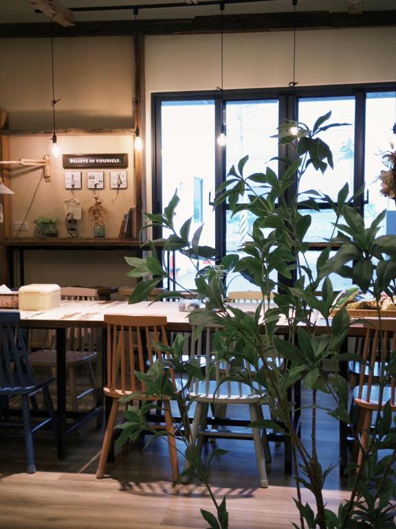 a plant in a room with a table and windows at 山沐三薰 2館 可包棟含蔬食早餐 in Shangwu