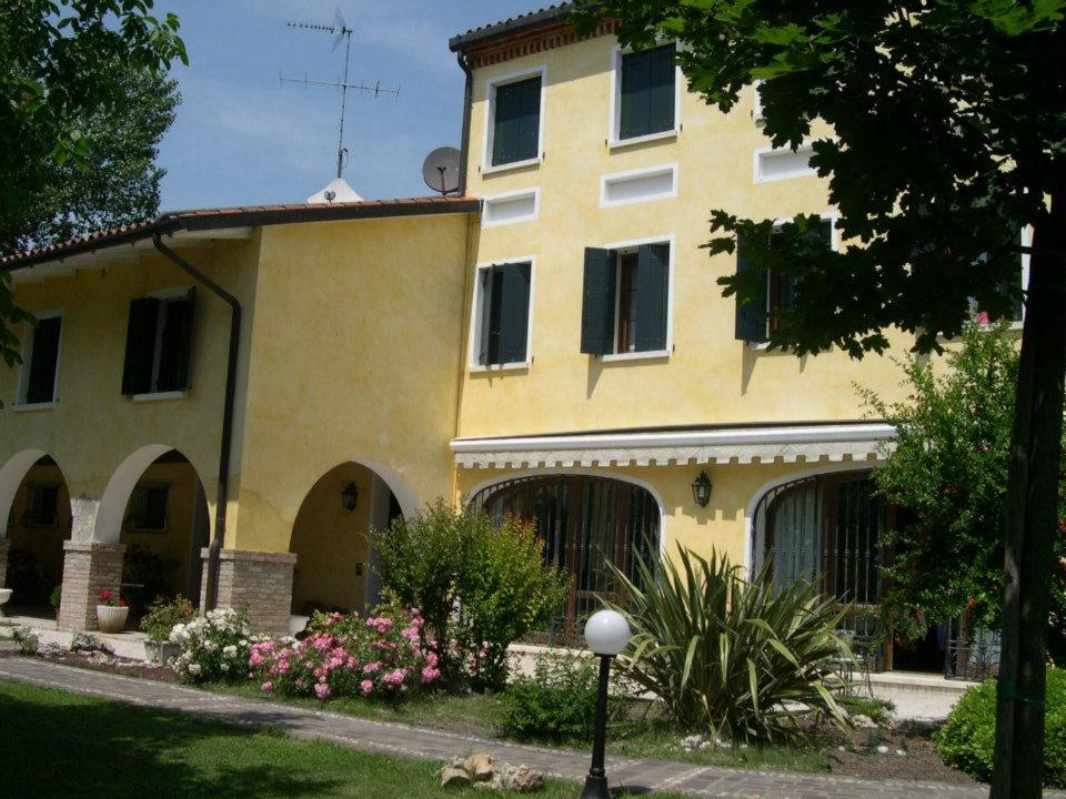 un gran edificio amarillo con muchas ventanas en Ca l'oasi, en San Donà di Piave