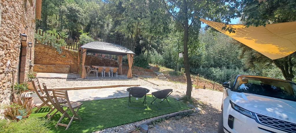 a backyard with a gazebo with chairs and a table at Masia Casa Nova de n'Illa in Montseny