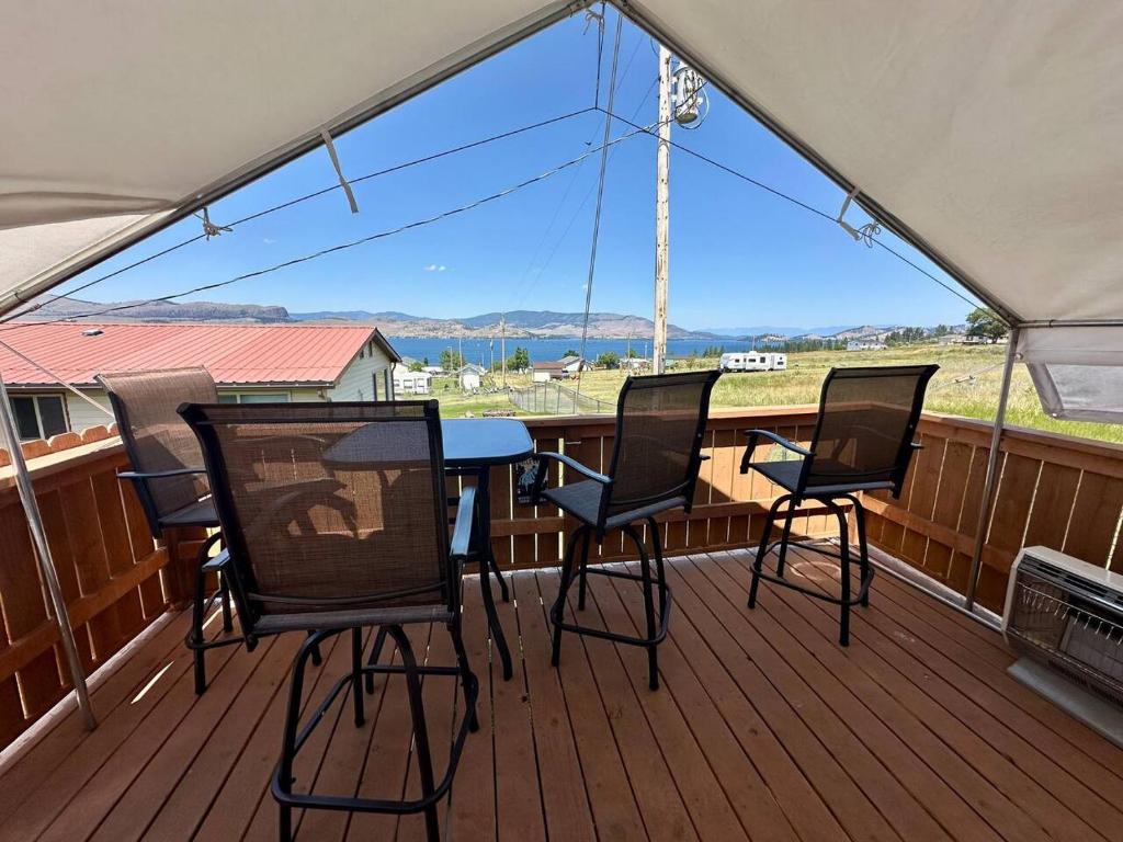 a patio with a table and chairs on a deck at GlampCamp in Big Arm