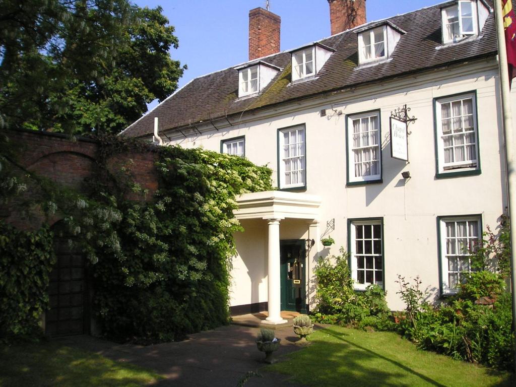 una vieja casa blanca con una hiedra creciendo a su alrededor en Chapel House, en Atherstone