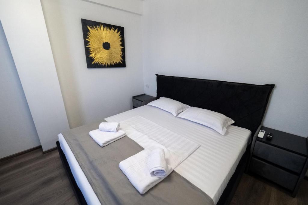 a bedroom with a bed with two towels on it at NORTH GATE Rooms in Afumaţi