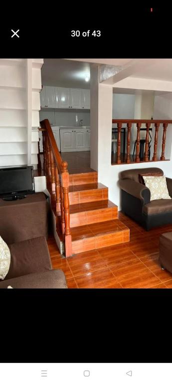 a living room with stairs and a couch at Jenny's accomodation in Baguio