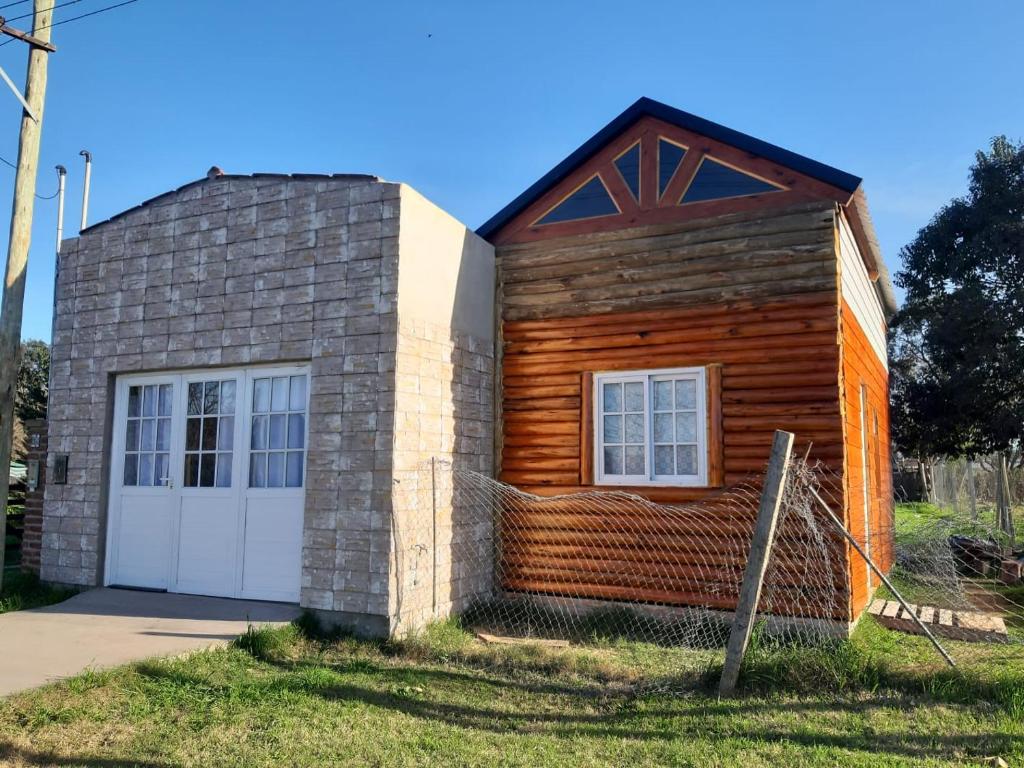 a small wooden house with a white garage at Cabaña-Villa General Savio in Sánchez