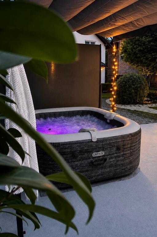 a jacuzzi tub sitting on a patio with lights at Guest House Kovačević in Korenica