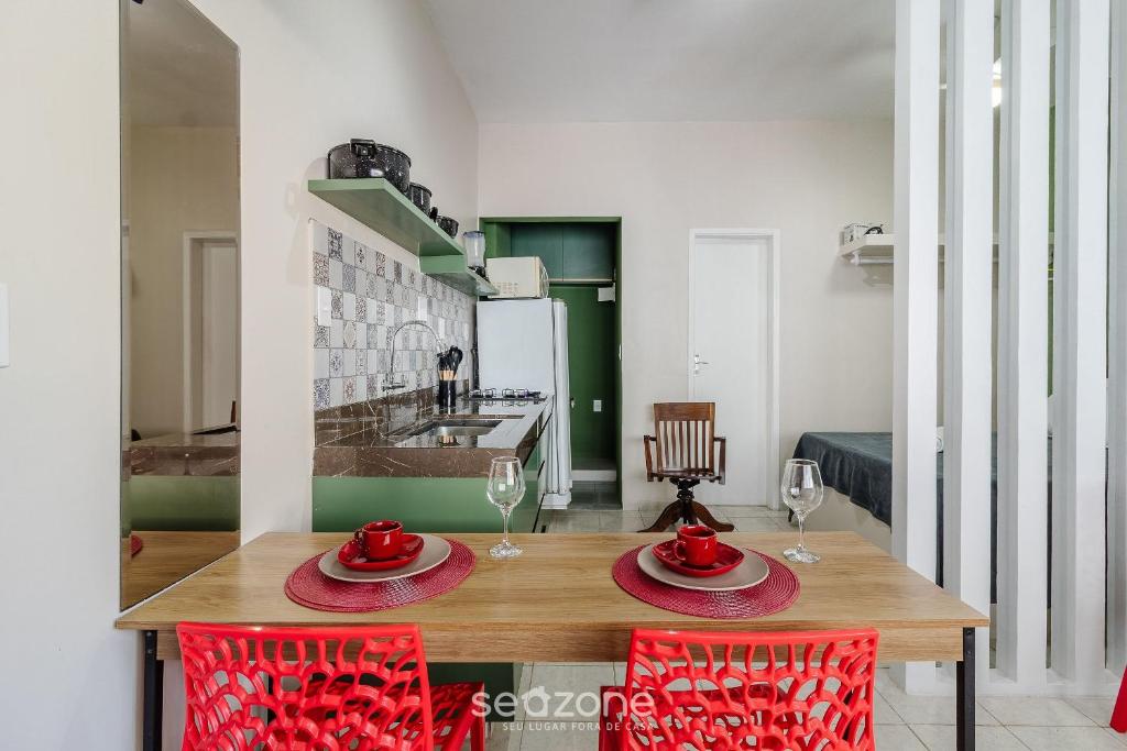 a dining room with a wooden table and red chairs at Studio the city center 300m Pelourinho HAI0203 in Salvador