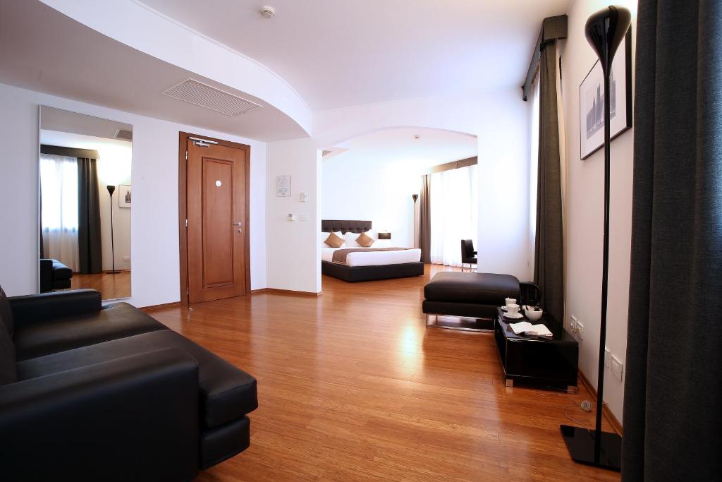 a living room with a couch and a bed at Hotel San Rocco in Muggia