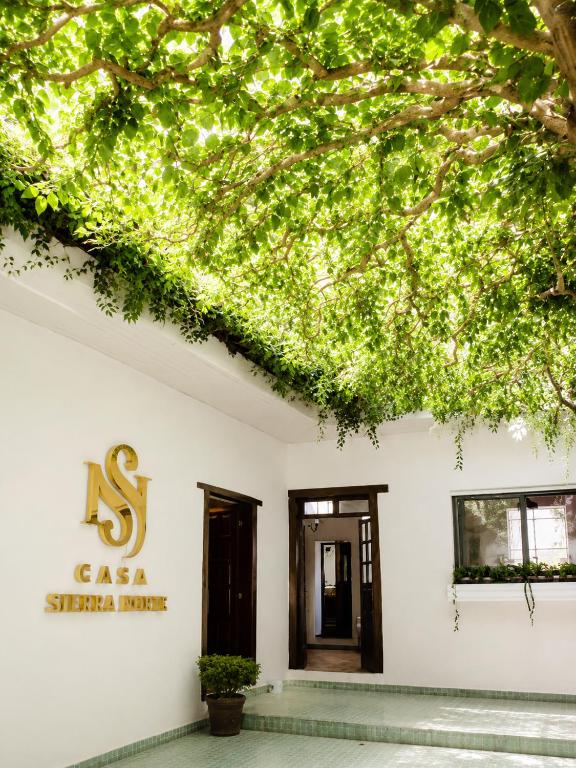 a white building with a sign that reads s csa sister hotel at Casa Sierra Norte in Zacatlán