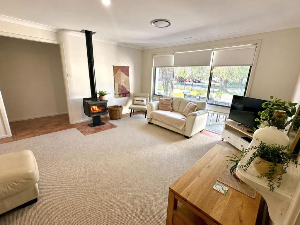 a living room with a couch and a fireplace at Zennor House - Busselton in Busselton